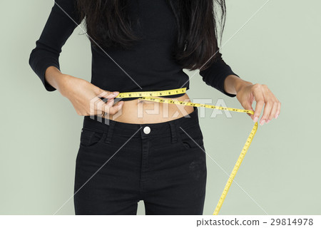 Young woman measuring her waist with tape Young woman measuring her waist with tape 29814978