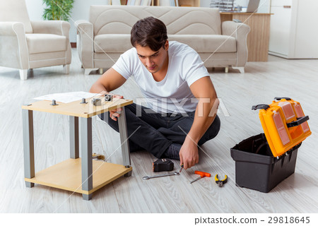Man assembling furniture at home 29818645