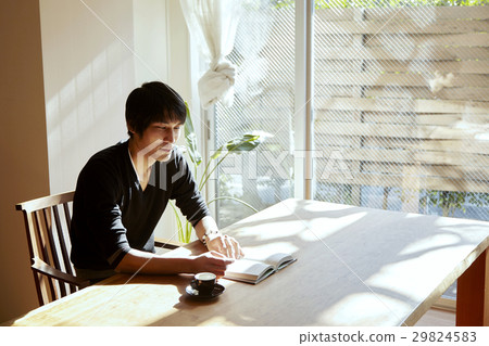 一個人在陽光充足的房間裡讀書。放鬆在度假，晴朗用餐的場面。 29824583