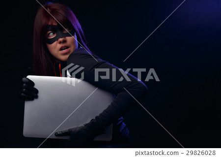 Woman thief cuddles stolen laptop 29826028