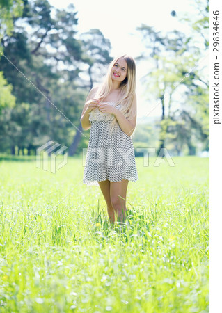 Woman walking through a meadow 29834646