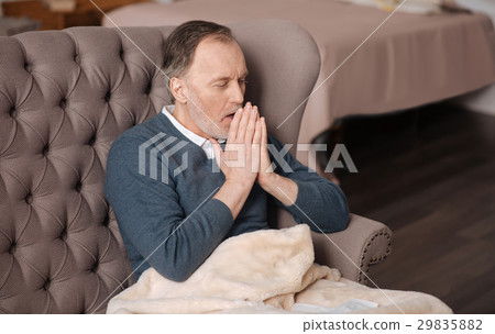 Old man coughing while sitting on couch Old man coughing while sitting on couch 29835882