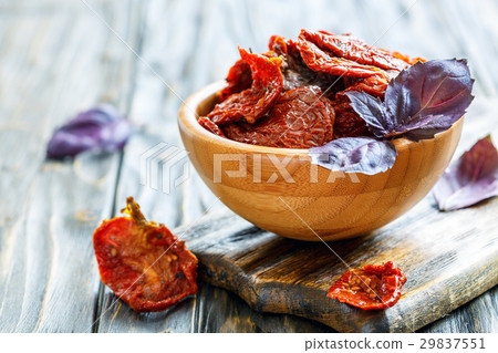 Sun-dried tomatoes and purple basil in a bowl. 29837551