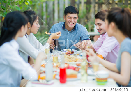 Asian group eating the evening they talking fun Asian group eating the evening they talking fun 29849413
