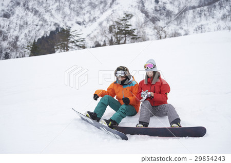A couple break that enjoys snowboarding 29854243