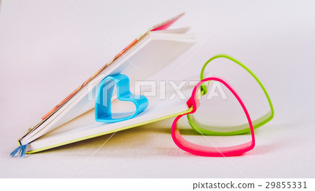 Blue red and green hearts holding pages of open Blue red and green hearts holding pages of open 29855331