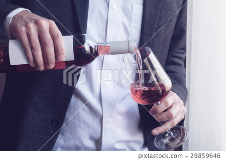 Man pouring rose wine into a glass 29859646