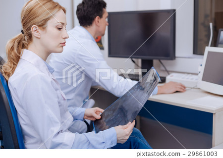 Serious female oncologist sitting in her chair Serious female oncologist sitting in her chair 29861003