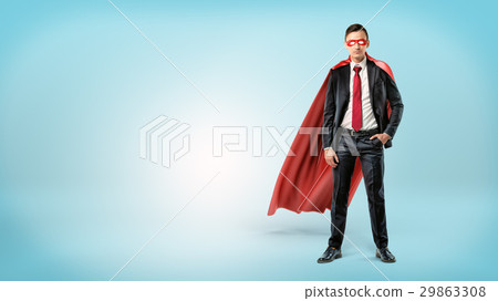 A self-assured businessman in a red cape and a A self-assured businessman in a red cape and a 29863308