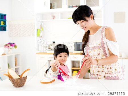 girl helping her mother prepare food in  kitchen 29873353