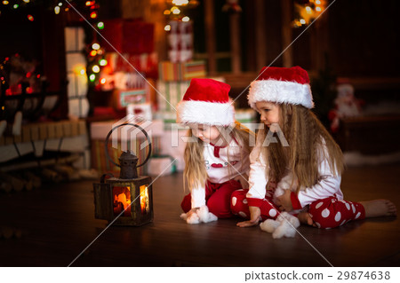 children girl looking at candle, Christmas tree 29874638