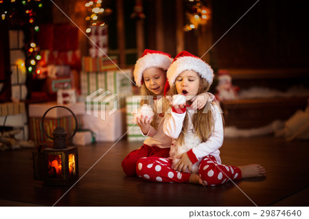 children girl looking at candle, Christmas tree 29874640