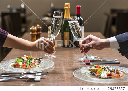 Two people toasting at a restaurant 29877857