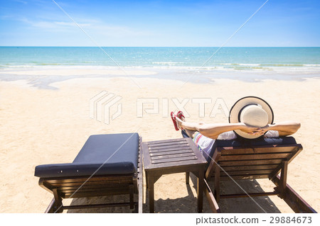 Woman relaxing on beach lounge chair or sun deck with sea view o 29884673