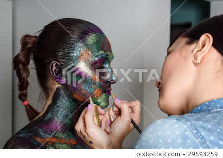 Makeup artist applies black paint and colourful 29893259