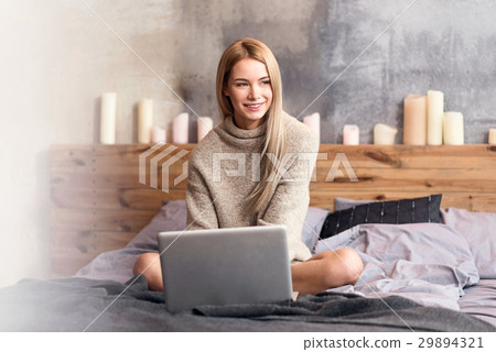 Delighted young woman using laptop at home Delighted young woman using laptop at home 29894321