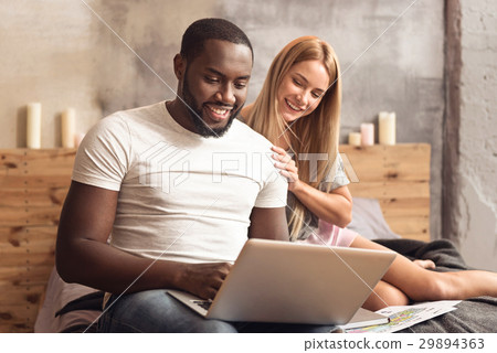 Cheerful international couple enjoying online 29894363