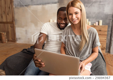 Happy international couple making online purchase Happy international couple making online purchase 29894367
