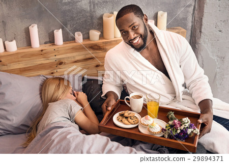 Careful African American man waking wife in the 29894371