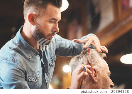Capable master cutting hair of the client in the Capable master cutting hair of the client in the 29894568
