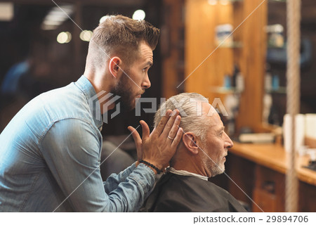 Stylish barber shaping haircut of the client in Stylish barber shaping haircut of the client in 29894706