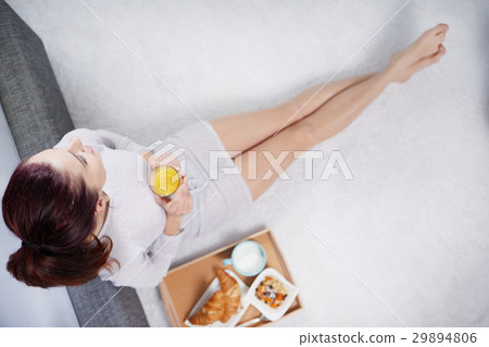 The girl in the morning eats a croissant and drink juice. top v The girl in the morning eats a croissant and drink juice. top v 29894806