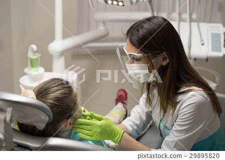 Female Dentist checking little girl patient Female Dentist checking little girl patient 29895820