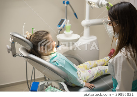 Dentist woman preparing little girl patient Dentist woman preparing little girl patient 29895821