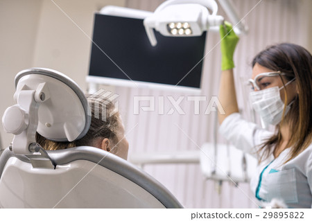 Dentist woman preparing light at dental clinic Dentist woman preparing light at dental clinic 29895822