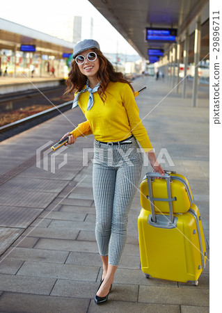 Beautiful young woman with suitcase is waiting a train 29896711