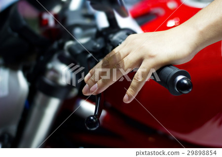 Hand on handlebars of motorcycle 29898854