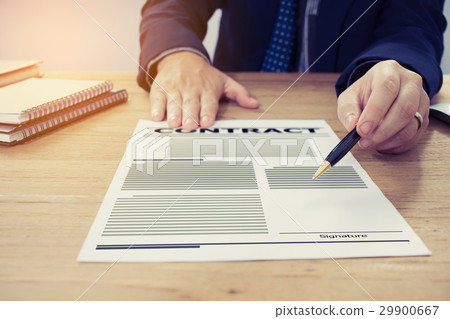 Businessman handing over a contract attached 29900667