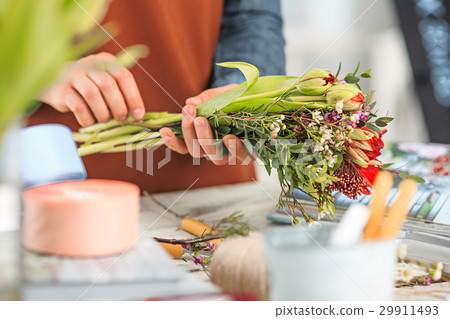 Florist at work: the female hands of woman making Florist at work: the female hands of woman making 29911493