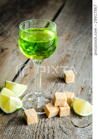 Glass of absinthe with lime and sugar cubes 29917867