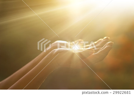Hands respecting and praying in sunbeam 29922681