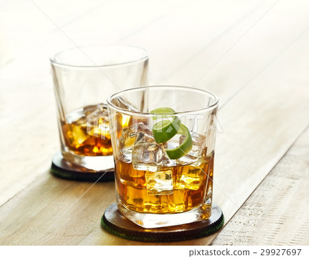 whiskey glasses with ice on wooden, warm tone 29927697