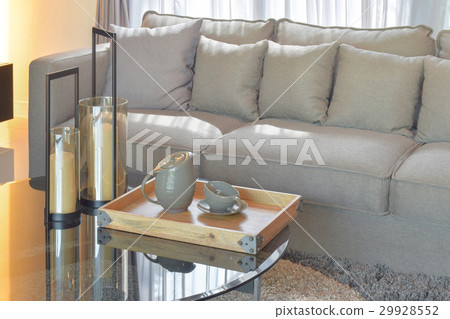Wood tray with pottery tea set on glass top table 29928552