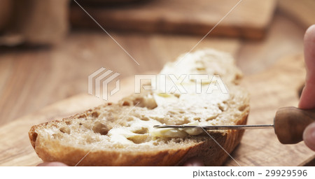 female teen hand spreads butter on slice of rustic female teen hand spreads butter on slice of rustic 29929596