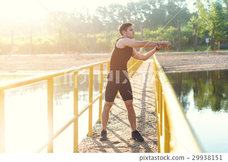 Jogger warming up exercising, stretching arms and Jogger warming up exercising, stretching arms and 29938151