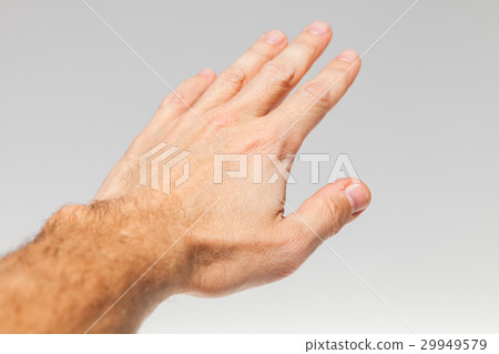 Male hand over gray wall background 29949579