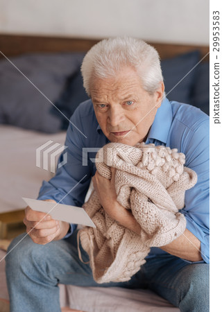 Sad depressed man pressing his wifes jacket to his 29953583