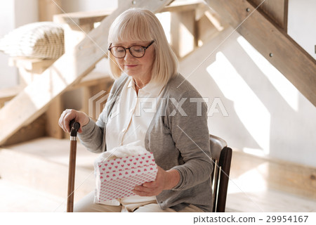 Sad elderly woman looking at the present 29954167