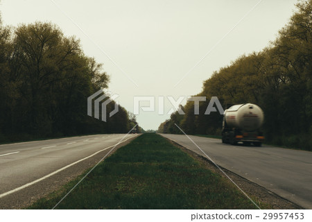 asphalt road and forest. Cars drive along the road 29957453