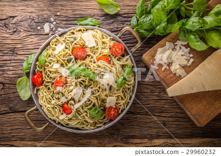 Italian spaghetti with basil pesto and tomatoes. Italian spaghetti with basil pesto and tomatoes. 29960232