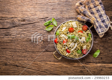 Italian spaghetti with basil pesto and tomatoes. Italian spaghetti with basil pesto and tomatoes. 29960233