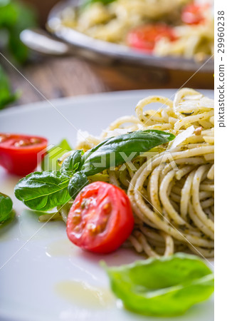 Italian spaghetti with basil pesto and tomatoes. Italian spaghetti with basil pesto and tomatoes. 29960238
