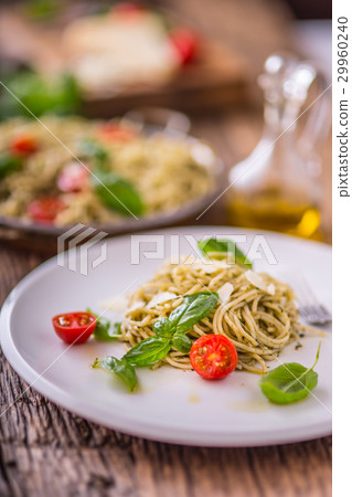 Italian spaghetti with basil pesto and tomatoes. Italian spaghetti with basil pesto and tomatoes. 29960240