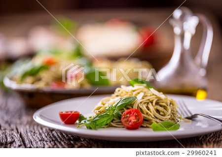 Italian spaghetti with basil pesto and tomatoes. Italian spaghetti with basil pesto and tomatoes. 29960241