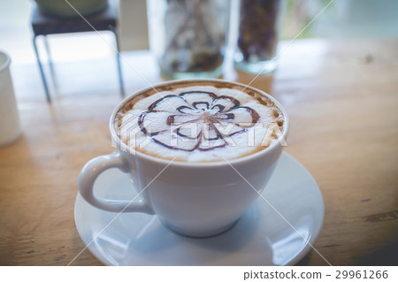 圖庫照片: hot coffee with foam milk art during working hour