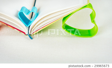 Blue and green hearts holding pages of open diary Blue and green hearts holding pages of open diary 29965673